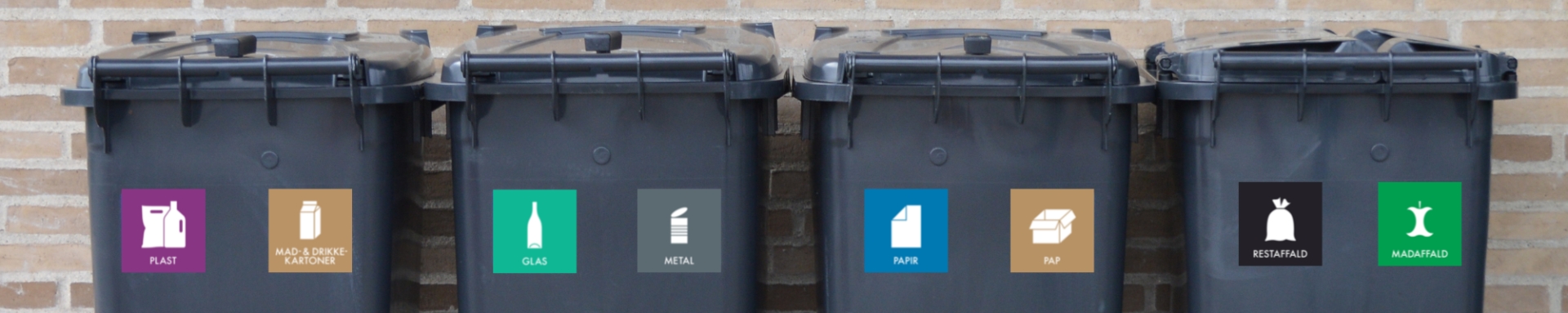 Fire sorte affaldsbeholdere på række med landsdækkende piktogrammer på