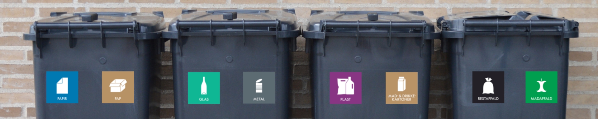 Fire sorte affaldsbeholdere på række med landsdækkende piktogrammer på