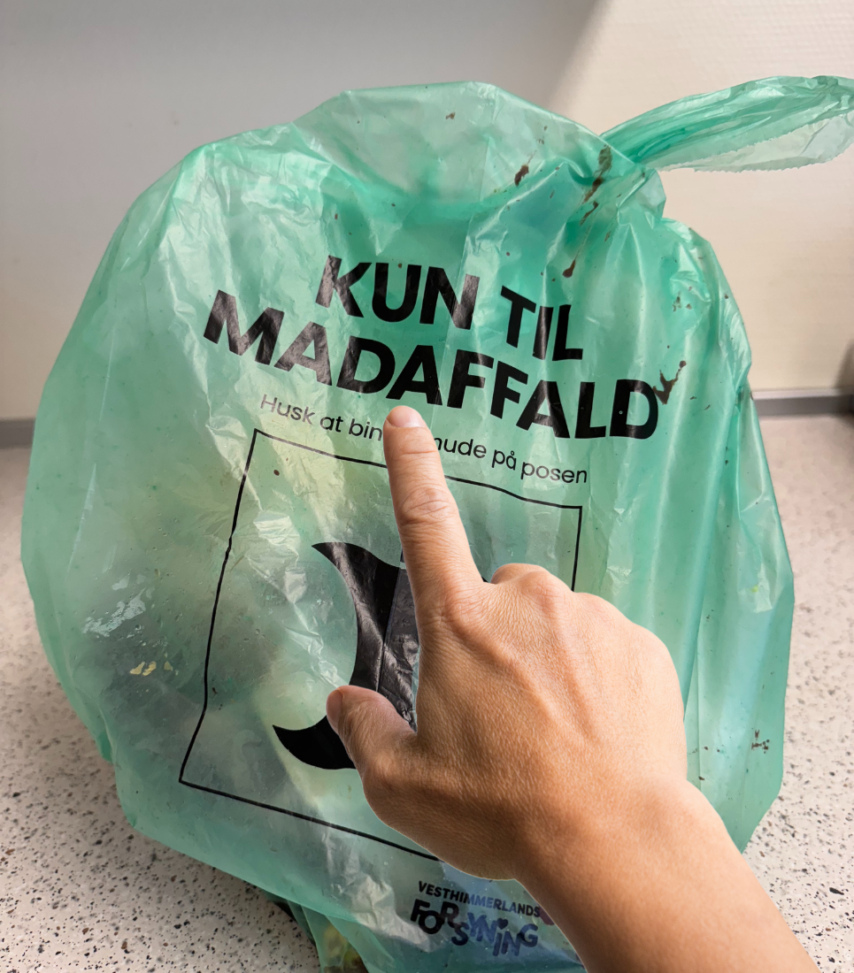 Grøn pose til madaffald Grøn pose til madaffald. Finger peger på teksten