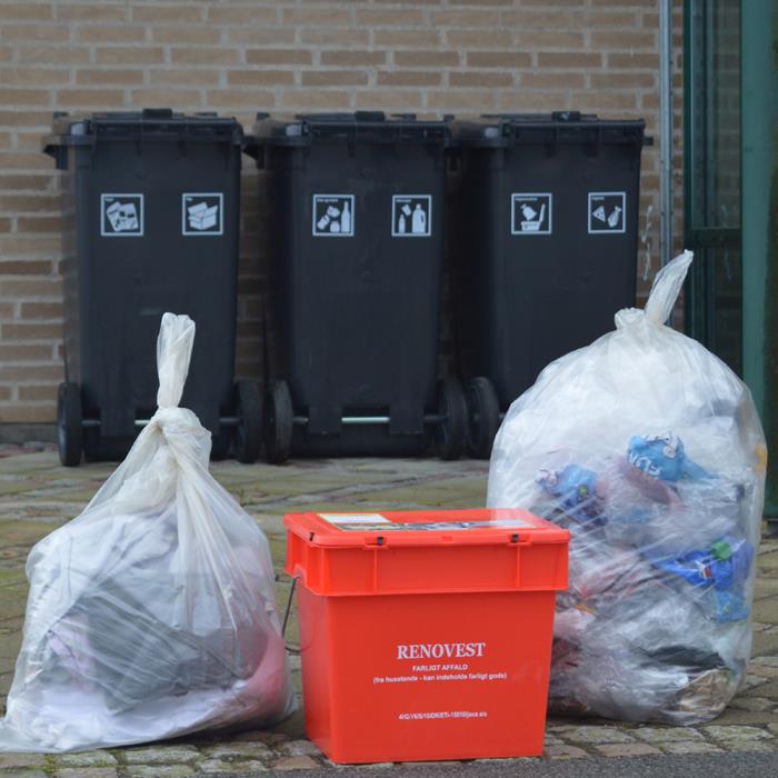 Her ser man to klare, fyldte affaldssække, en rød miljøkasse og tre sorte affaldscontainere 
