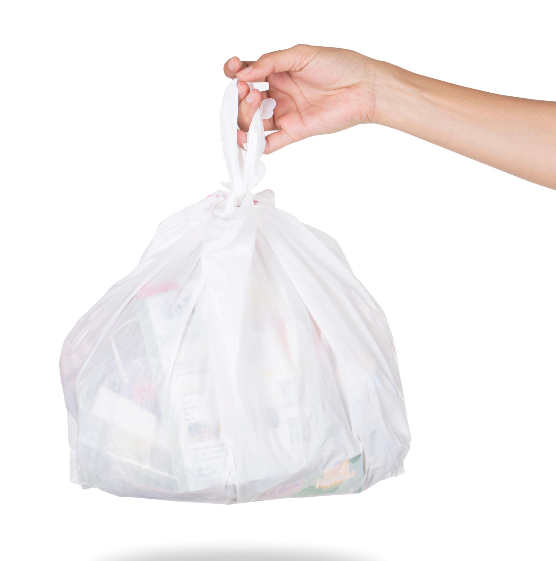 Her ser man et billedet af en hvid affaldspose med en knude i toppen. En hånd holder posen. Man ser hånd og underarm. Baggrunden er helt hvid.