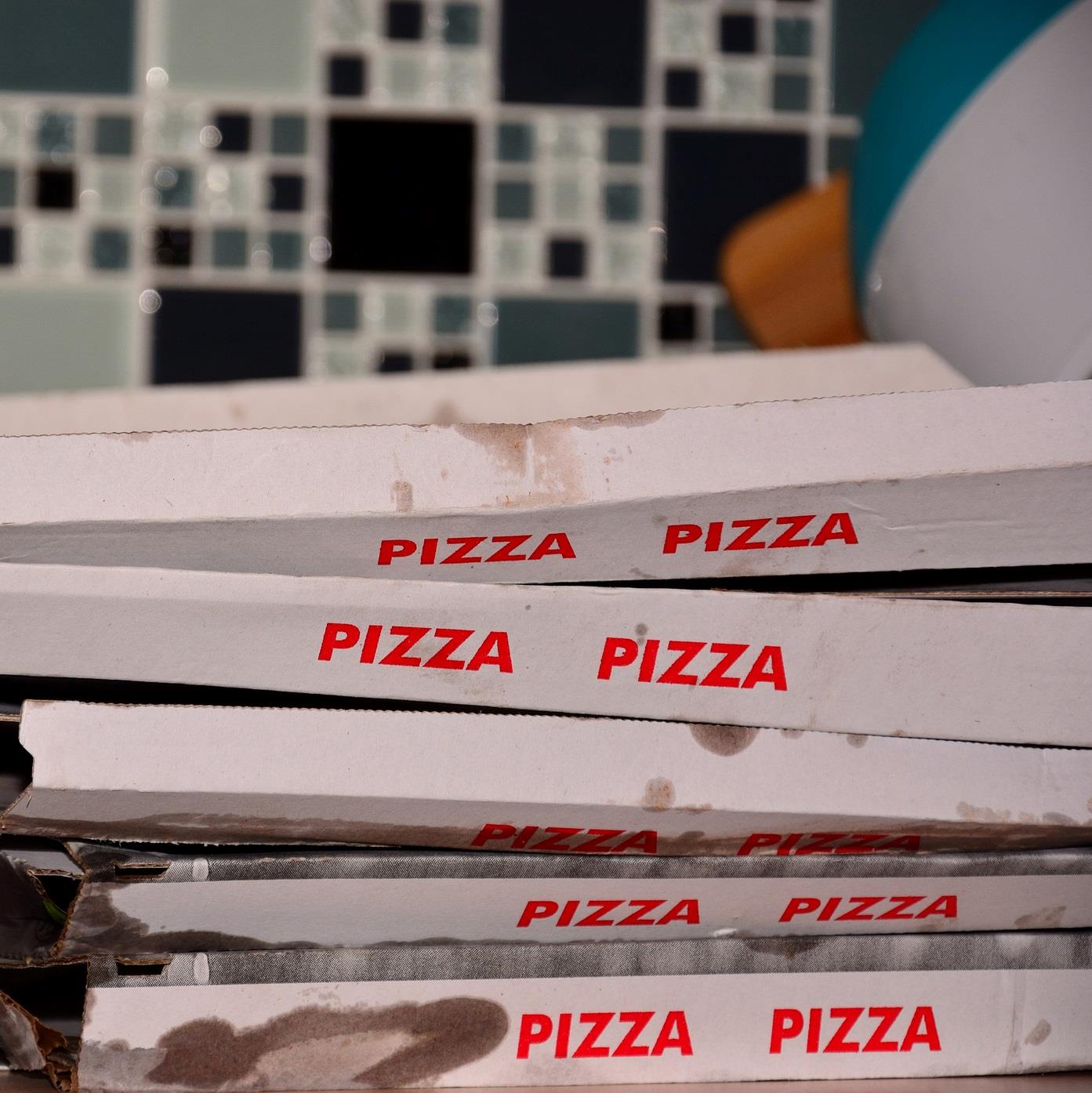 Fem snaskede pizzabakker ligger ovenpå hinanden