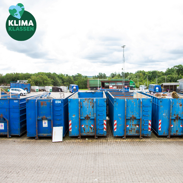Blå containere står på række på en genbrugsplads