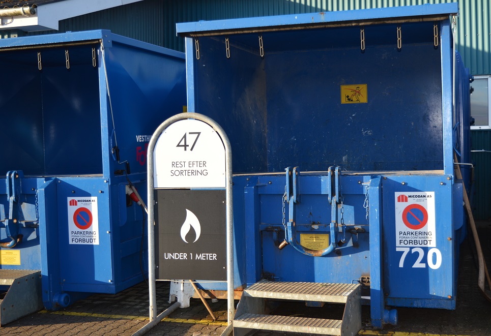 Blå container på genbrugsplads. På skiltet ved siden af står der 47 "Rest efter sortering under 1 meter"