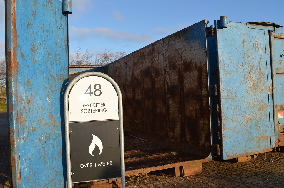 Blå container på genbrugsplads. På skiltet ved siden af står der "48 Rest efter sortering - over 1 meter"
